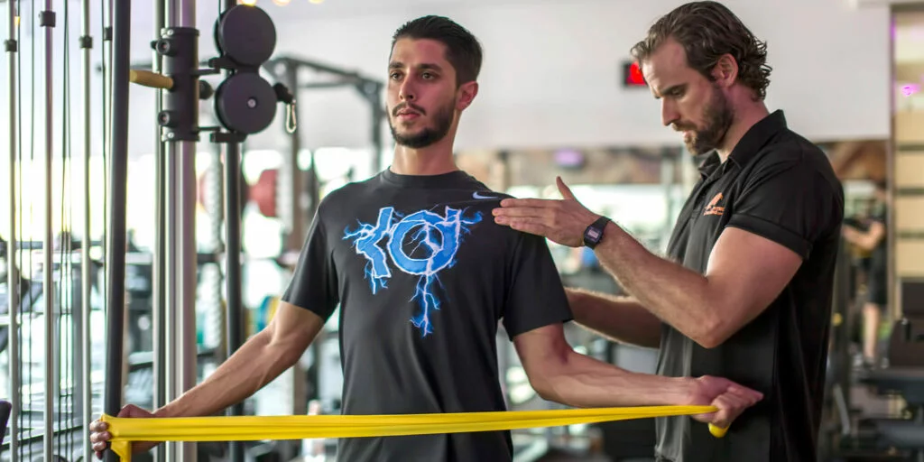 Physiotherapist guiding patient through resistance band rehabilitation exercise